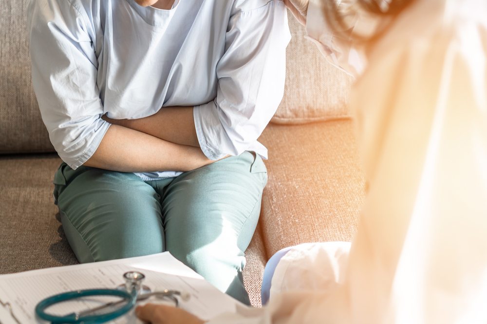 Abdominal pain patient woman having medical exam with doctor