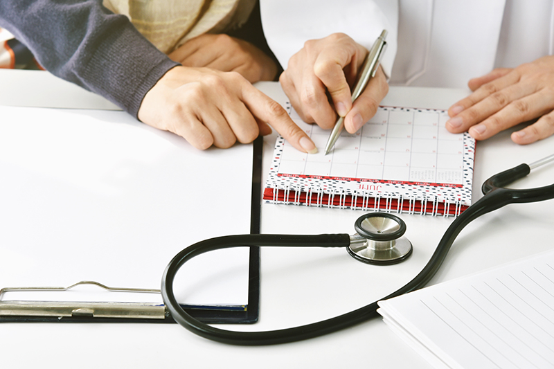 Doctor and patient make an annual health checkup appointment at
