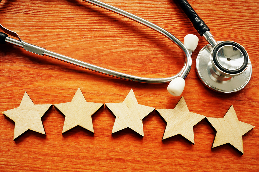 Patient experience and satisfaction concept. Stethoscope and five stars.