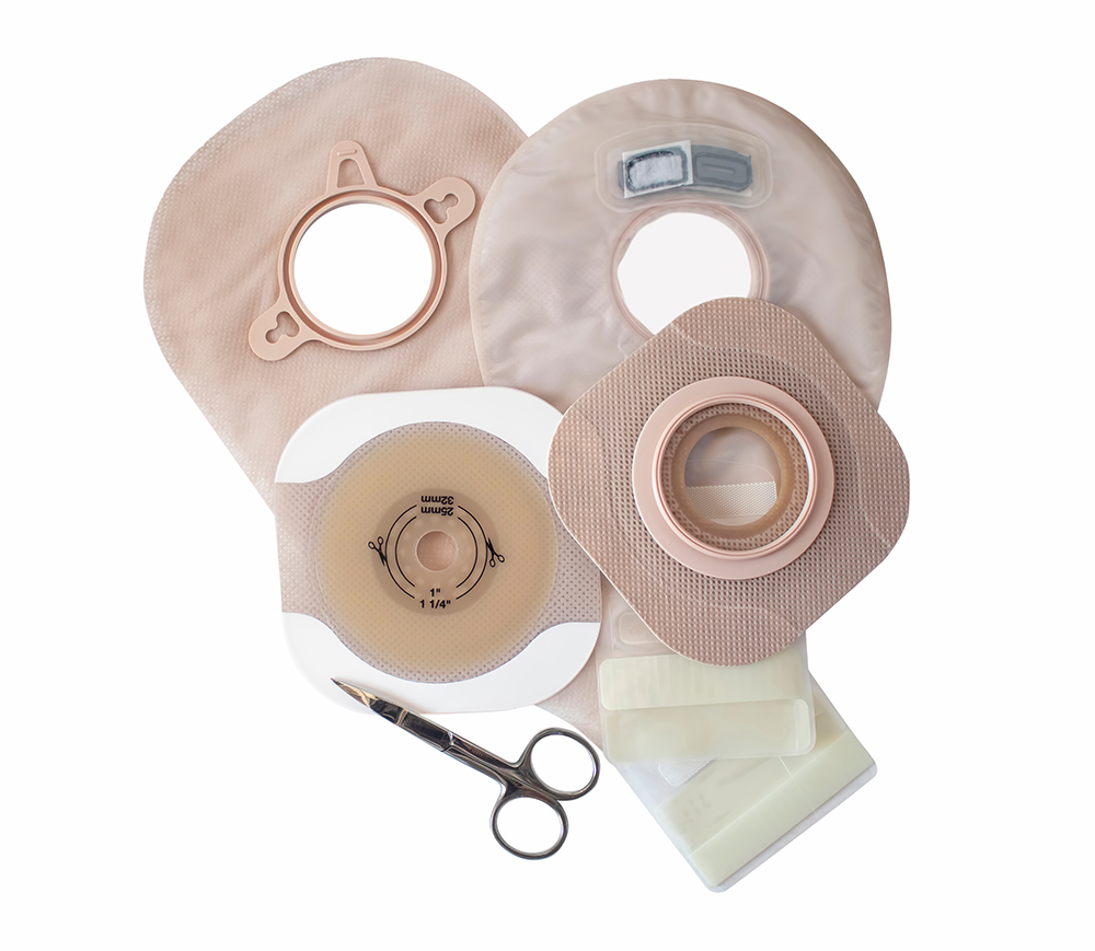 Two piece ostomy appliance including flange, pouch and scissor isolated a a white background